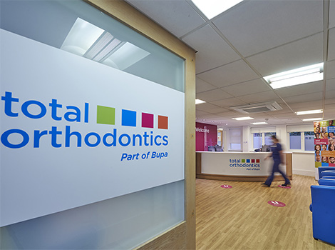 Total Orthodontics Tonbridge reception desk with colourful logo