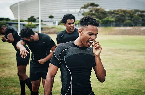 Man taking out gumshield on rugby pitch