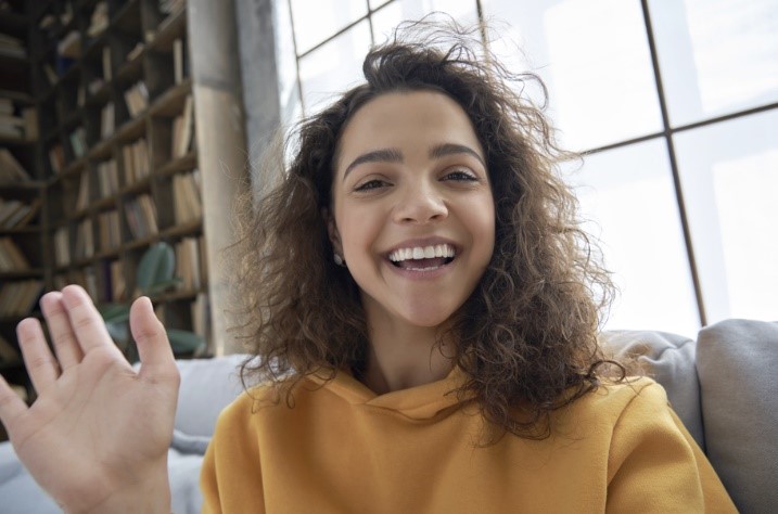 curly hair girl waving hello 