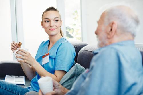 A man sits on a sofa with his orthodontist discussing his treatment in a relaxed environment to help him overcome his fear of the orthodontist
