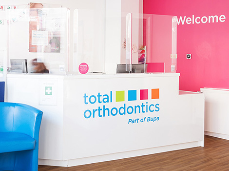 Reception desk with pink wall at Total Orthodontics Eastbourne