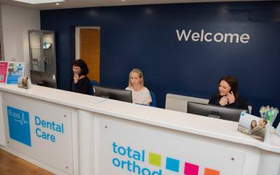 The reception desk is staffed by three staff members at Total Orthodontics Harrogate