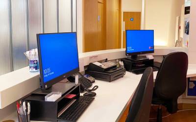 The reception desk at Total Orthodontics Sevenoaks has screens and chairs for two reception staff