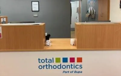 Reception desk at Total Orthodontics with practice logo