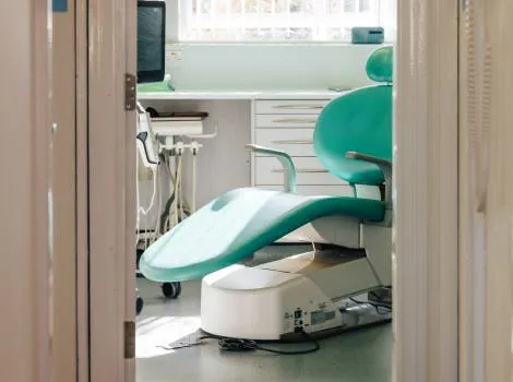 Light filled modern dental surgery with pale green chair