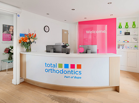 Total Orthodontics Uckfield reception desk with colourful Total Orthodontics logo