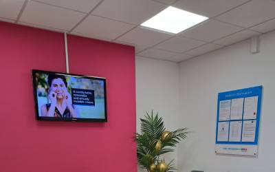 Practice TV showing useful videos and noticeboard for patients to read on the walls 